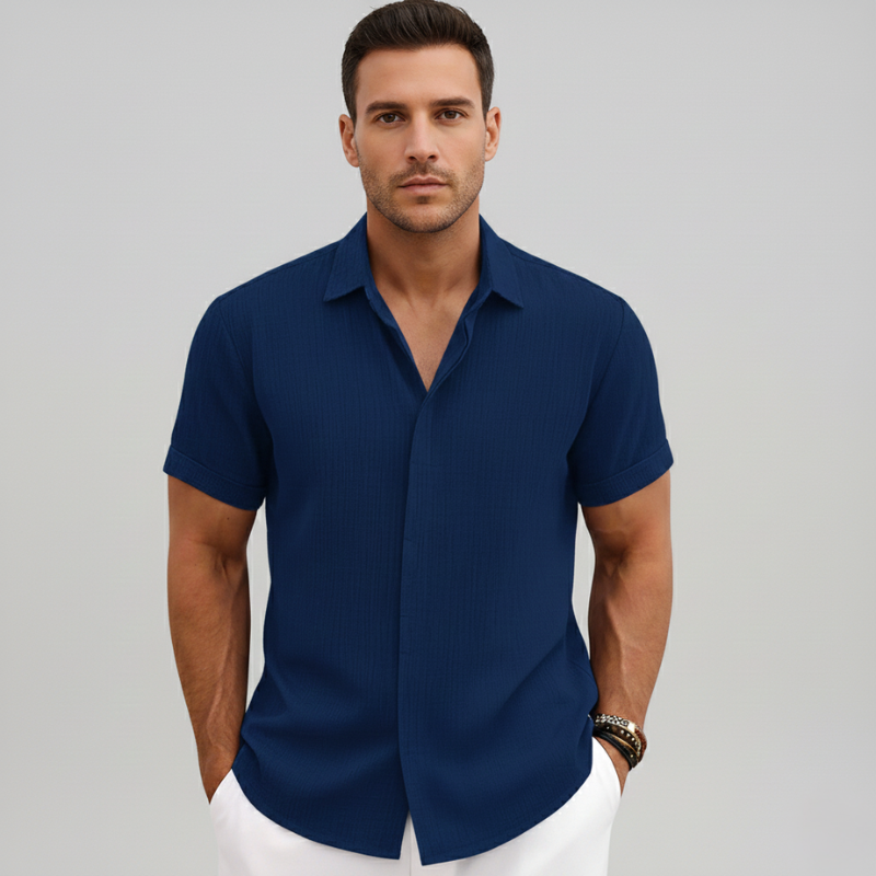 Man wearing a navy short-sleeve button-up shirt with a structured collar and modern relaxed fit.