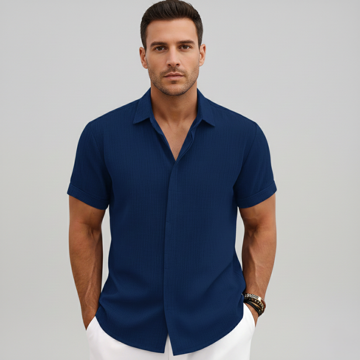 Man wearing a navy short-sleeve button-up shirt with a structured collar and modern relaxed fit.