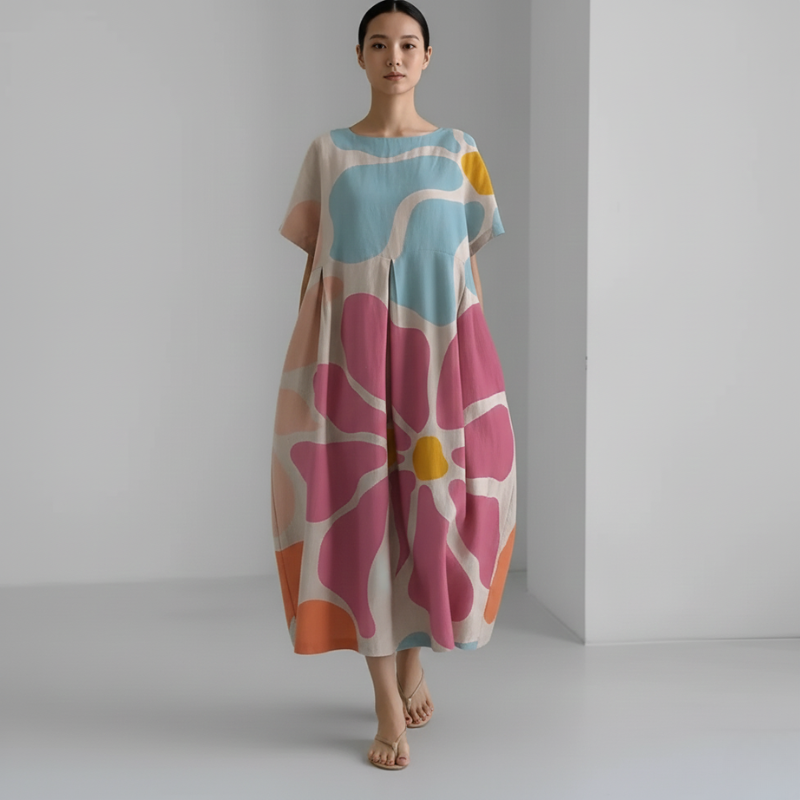 Woman wearing a colorful floral dress against a plain background