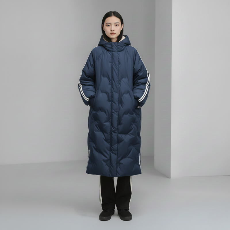 Person wearing a long navy blue puffer coat with white stripes on a gray background