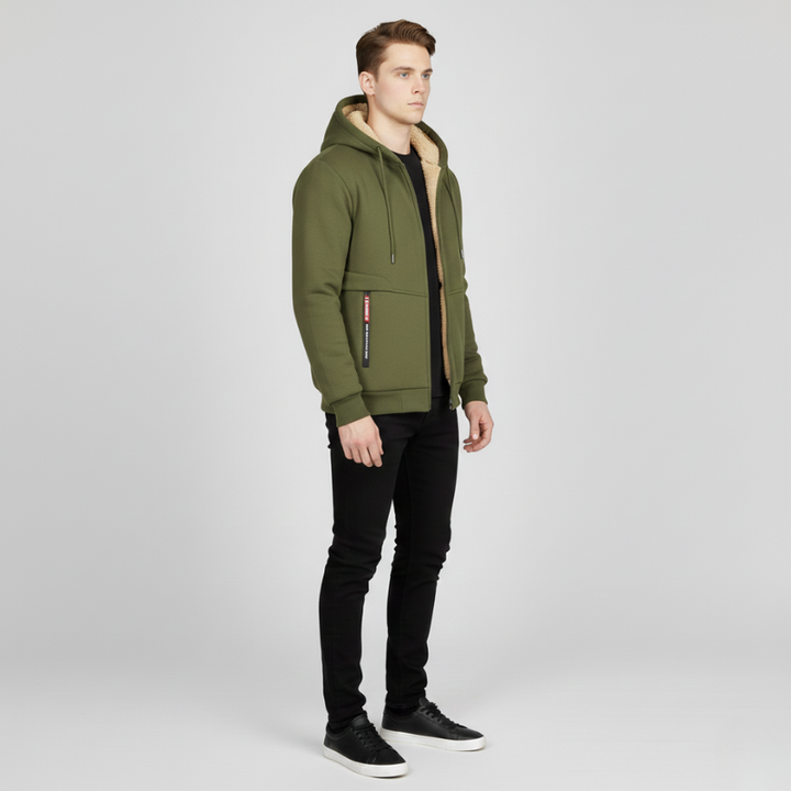 Side view of a man wearing an olive green sherpa lined hoodie with black pants and black sneakers.