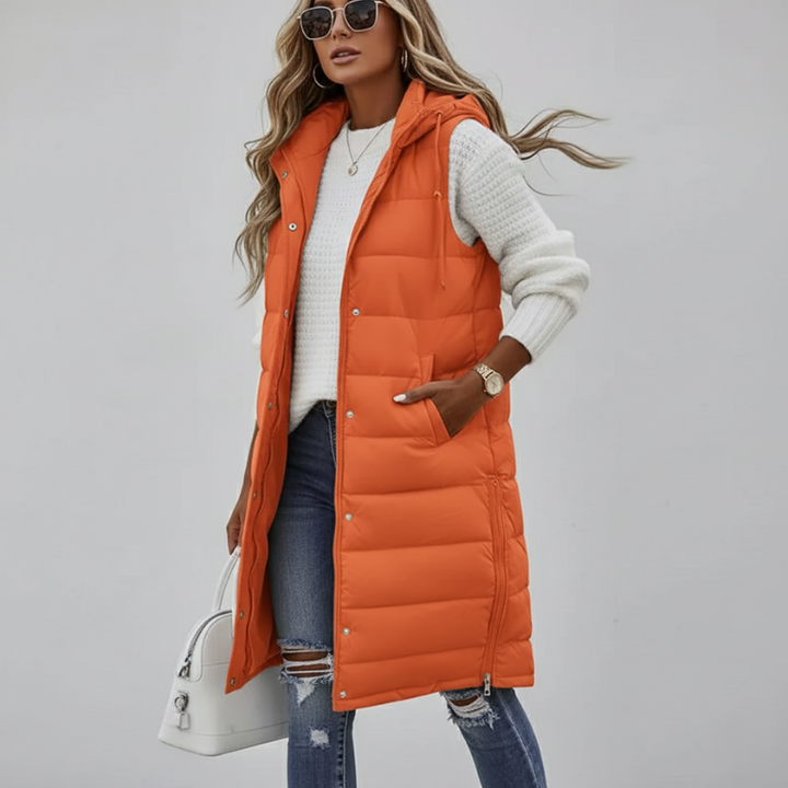 model posing in bright orange long puffer vest showing sleeveless winter fashion
