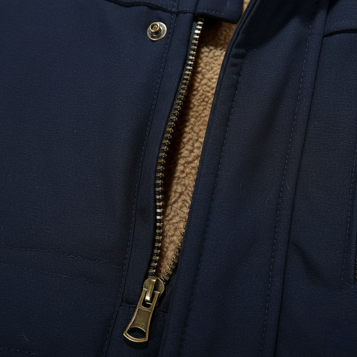 Close-up of a navy parka showing the zipper, stitching, and textured fabric with warm inner lining.