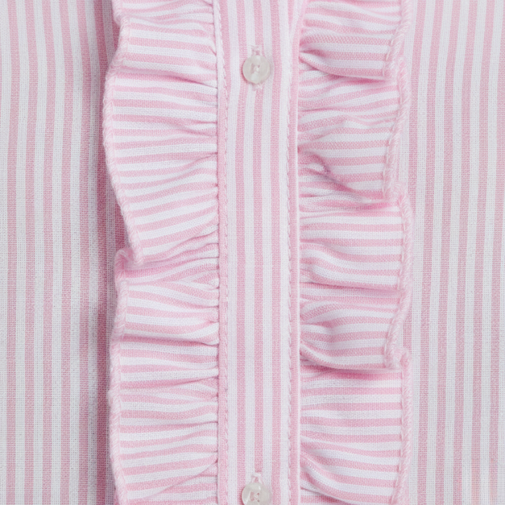 Close-up image showing the pink striped ruffle detailing and stitching on the front of the women’s button shirt.