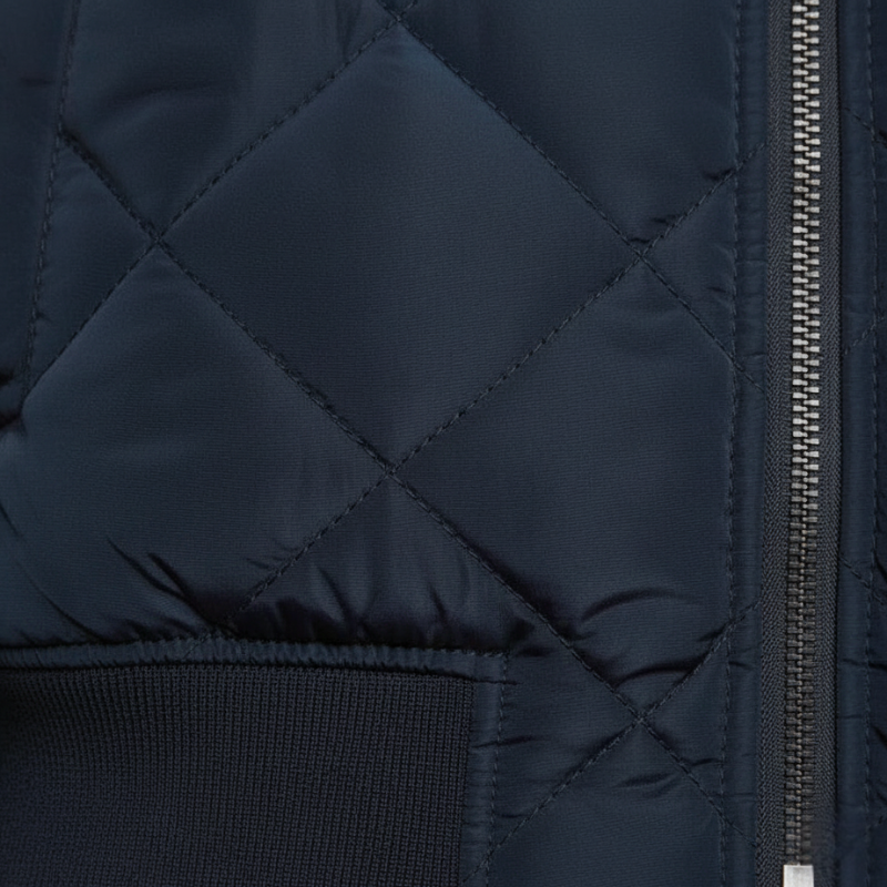Nahaufnahme der navyblauen Steppjacke mit diagonaler Steppstruktur und fein gearbeiteter Oberfläche.