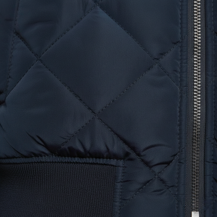 Nahaufnahme der navyblauen Steppjacke mit diagonaler Steppstruktur und fein gearbeiteter Oberfläche.