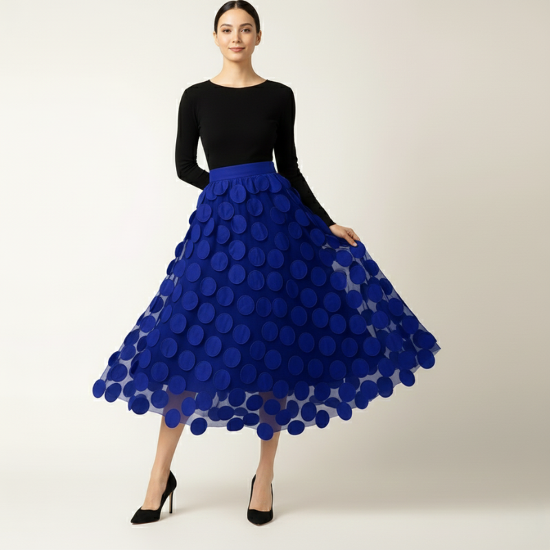 Woman wearing a black top and blue polka dot skirt on a white background