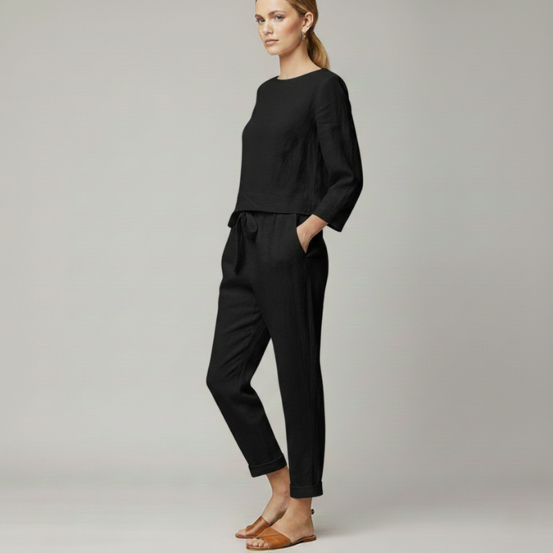Woman walking in a black knit lounge outfit with a relaxed fit top and tapered jogger pants.