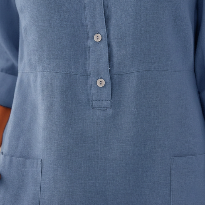 Female model in a blue linen-blend dress featuring 3/4 sleeves, a straight silhouette, and button neckline in studio lighting.