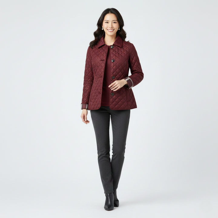 Woman wearing a burgundy quilted jacket paired with black trousers in a studio environment.