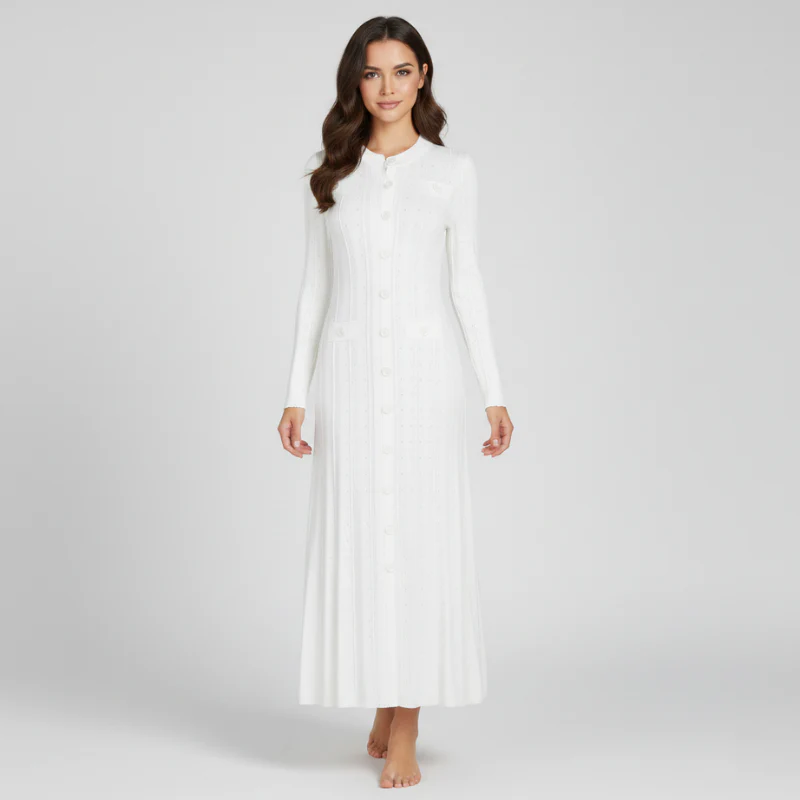 Woman wearing a white long-sleeve dress against a plain background