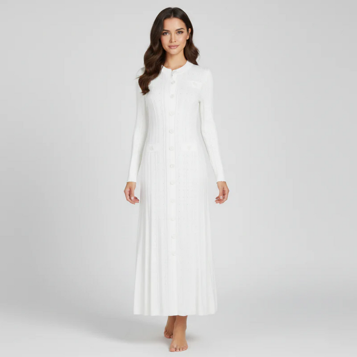 Woman wearing a white long-sleeve dress against a plain background