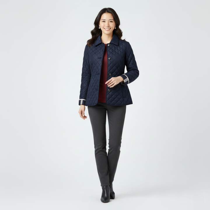 Woman wearing a navy quilted jacket with black pants in a clean studio setting.