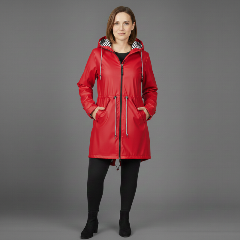 Woman wearing a bright red hooded winter coat standing in a studio setting.