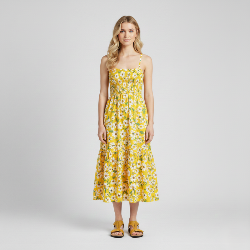 Woman wearing black sandals styled with a yellow floral dress in a bright indoor studio.