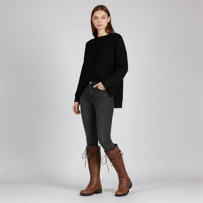 Woman wearing a black sweater, gray pants, and brown boots on a white background