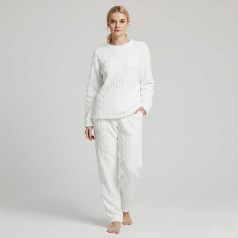 Woman standing in a white fleece lounge outfit featuring a soft long-sleeve top and warm pants.