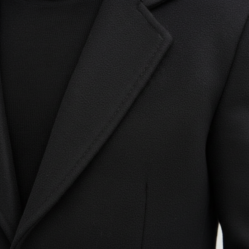 Close-up of a black blazer with a focus on the lapel and collar.