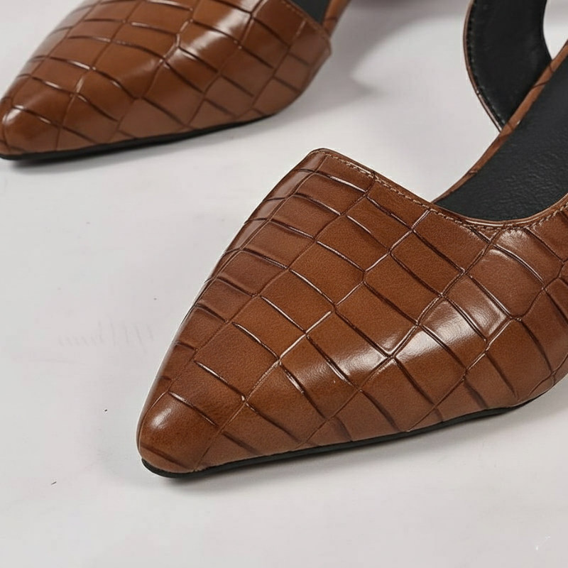 Close-up of a brown woven leather pointed toe heel showing textured weave and premium stitching.
