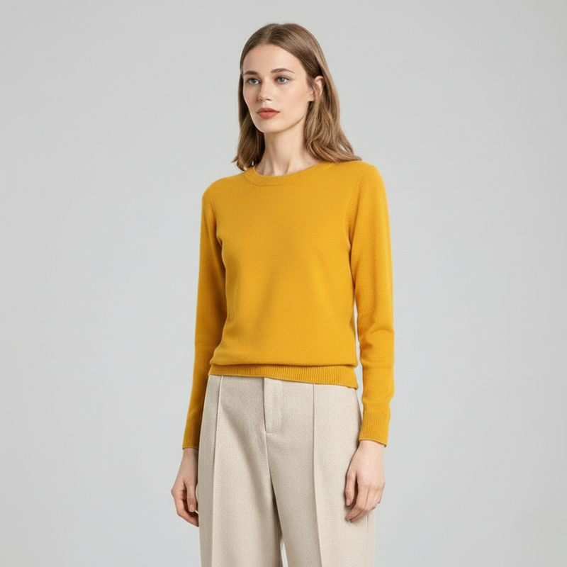 Woman wearing a mustard yellow knit sweater with beige pants in a bright studio, showing classic women’s knitwear.