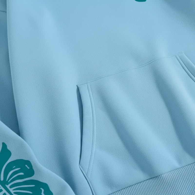 Light blue sweatshirt with a pocket and green logo on a matching fabric background